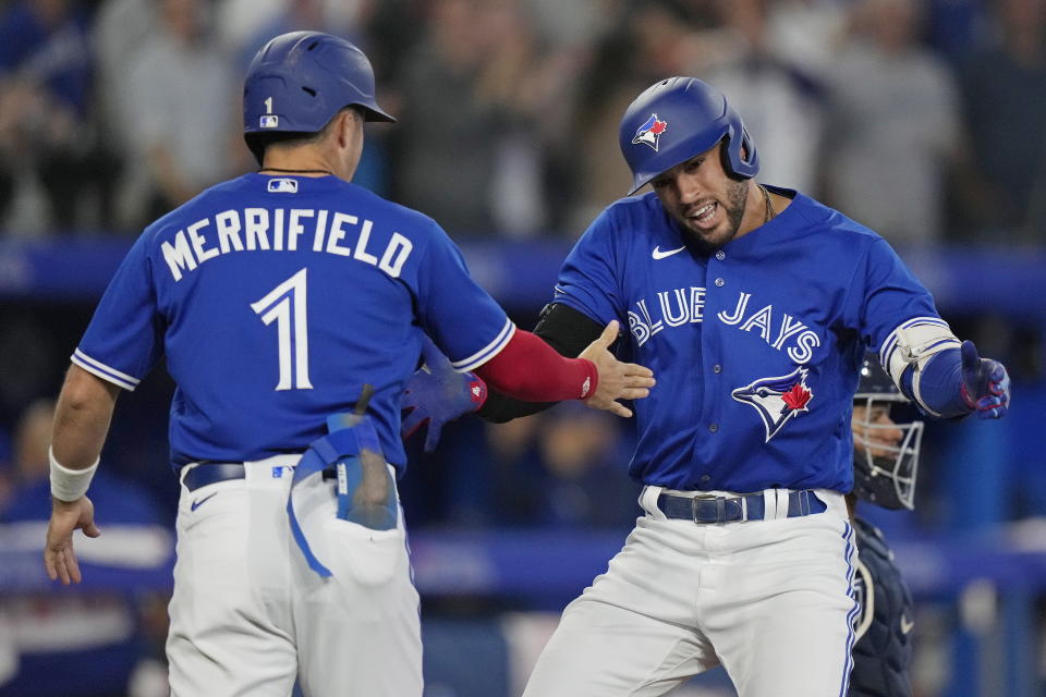 George Springer, de los Azulejos de Toronto, festeja su jonrón de dos carreras con su compañero Whit Merrifield, en el segundo duelo de una doble tanda ante los Rays de Tampa Bay, el martes 13 de septiembre de 2022 (Frank Gunn/The Canadian Press via AP)