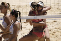 Anouk Verge-Depre, second from right, of Switzerland, hugs teammate Joana Heidrich as they celebrate winning a women's beach volleyball Bronze match against Latvia at the 2020 Summer Olympics, Friday, Aug. 6, 2021, in Tokyo, Japan. (AP Photo/Petros Giannakouris)