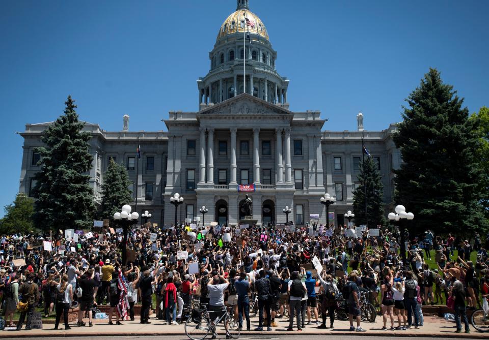 People chant on the steps of the Colorado Capitol in Denver on May 29, 2020, during a protest in response to the police killing of George Floyd, an unarmed Black man in Minneapolis.