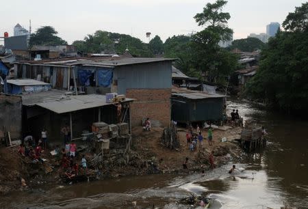 People gather near their houses at a slum area at the Ciliwung river bank at Jatinegara district in Jakarta, Indonesia, December 29, 2016. Picture taken December 29, 2016. REUTERS/Beawiharta