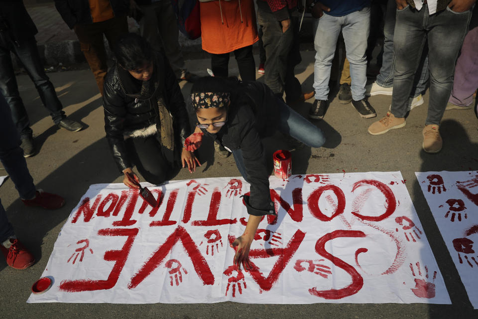Indian students of the Jamia Millia Islamia University prepare banners during a protest against a new citizenship law, in New Delhi, India, Wednesday, Dec. 18, 2019. India’s Supreme Court on Wednesday postponed hearing pleas challenging the constitutionality of the new citizenship law that has sparked opposition and massive protests across the country. (AP Photo/Altaf Qadri)