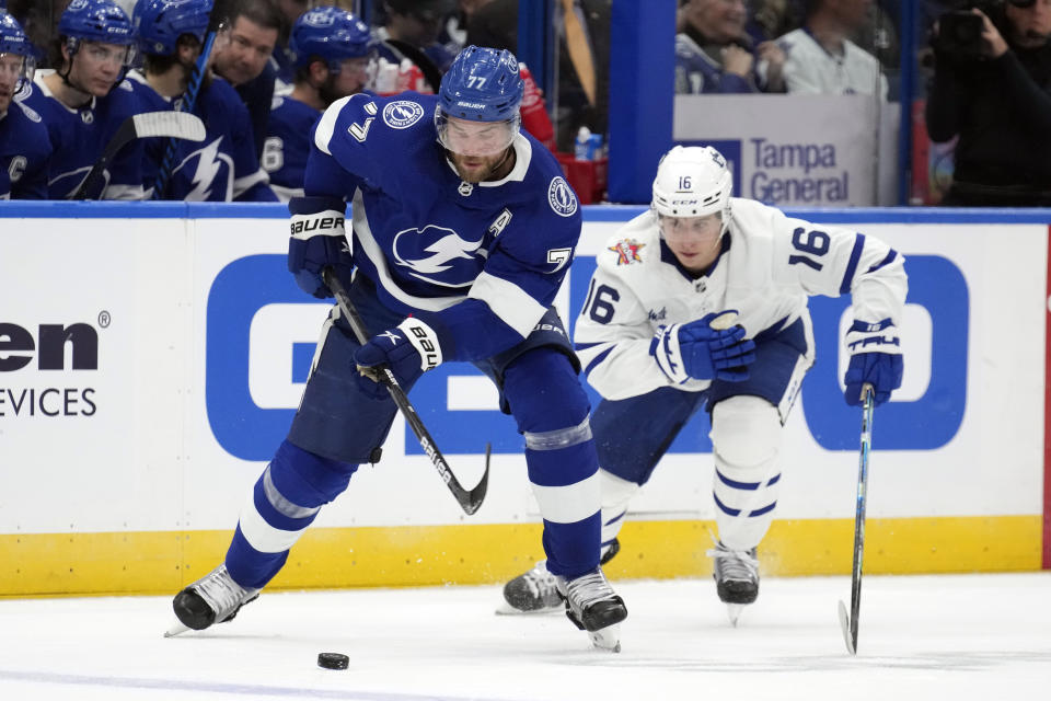 Tampa Bay Lightning defenseman Victor Hedman (77) moves the puck ahead of Toronto Maple Leafs right wing Mitchell Marner (16) during the first period of an NHL hockey game Saturday, Oct. 21, 2023, in Tampa, Fla. (AP Photo/Chris O'Meara)