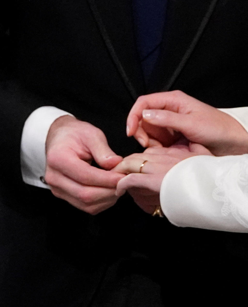 Jack Brooksbank slips a wedding band on Eugenie's finger (the groom will not wear one).