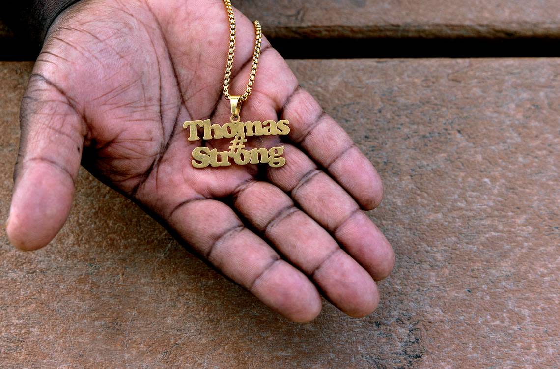 Atari Thomas holds a necklace his late wife, Tiffany, had made to celebrate their family.