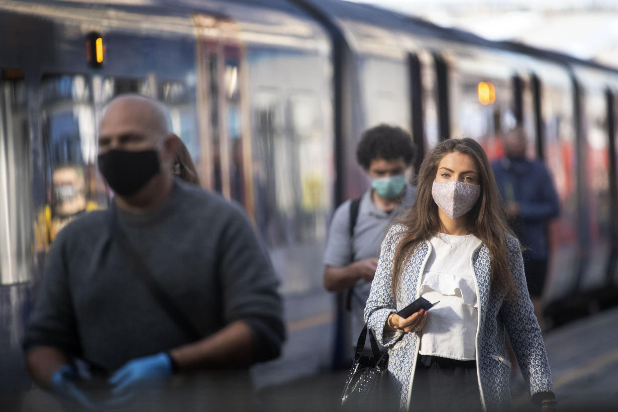 Passengers wearing face masks at Waterloo station as face coverings become mandatory to wear on public transport in the country, with the easing of further lockdown restrictions introduced to combat the spread of coronavirus, in London, Monday June 15, 2020. (Victoria Jones/PA via AP)