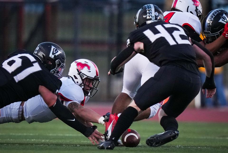 Vandegrift defensive lineman Ian Witt, far left, and linebacker Adam Scott scramble for a fumble with Manor quarterback Jayson Zardavets. The Vipers held the Mustangs scoreless until Zardavets threw a touchdown pass in the final minute of the game.