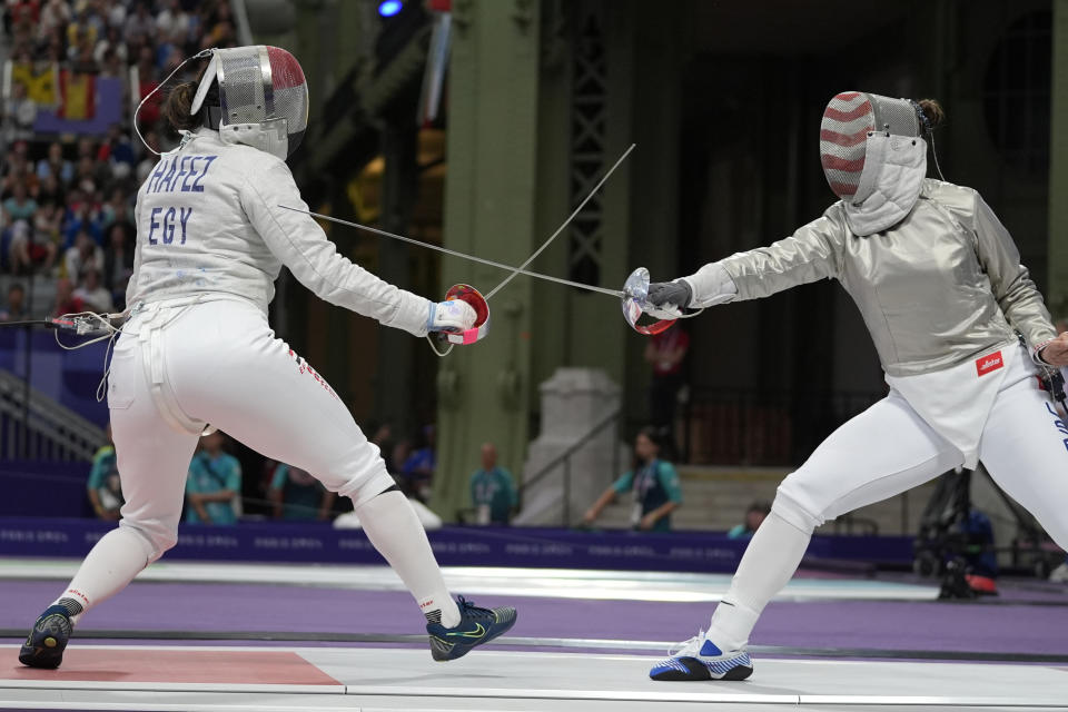 La egipcia Nada Hafez (izquierda) y la estadounidense Elizabeth Tartakovsky compiten en el sable femenino de la esgrima de los Juegos Olímpicos de París, el lunes 29 de julio de 2024. (AP Foto/Andrew Medichini)