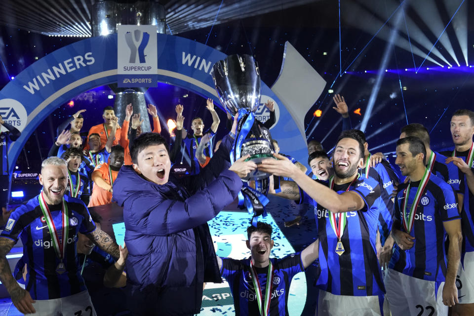 Inter Milan's President Steven Zhang, left, holds the trophy as he celebrates with players after winning the Italian Super Cup final soccer match between AC Milan and Inter Milan at the King Saud University Stadium, in Riyadh, Saudi Arabia, Wednesday, Jan. 18, 2023. Inter Milan won 3-0. (AP Photo/Hussein Malla)