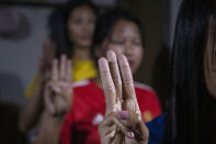 Police officers who fled Myanmar following a military coup display the three-finger salute at an undisclosed location bordering Myanmar, in the northeastern Indian state of Mizoram, Thursday, March 18, 2021. A group of Myanmar policemen raised athree-finger salute, a symbol of resistance, as they recounted their escape to India, after defying the Myanmar army orders to shoot people who opposed the Feb. 1 army coup in southeast Asian country. “We cannot hurt our people, that’s why we came to Mizoram,” said one of them, who hailed from the northwestern town of Tedim in Myanmar. (AP Photo/Anupam Nath)