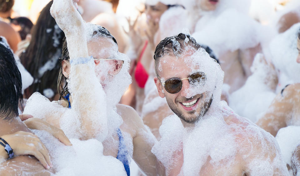 Conversations around foam parties cause eye irritation have been happening since the early 2000s. (Images via Getty) Joyful couple having fun at paint party on the beach music festival