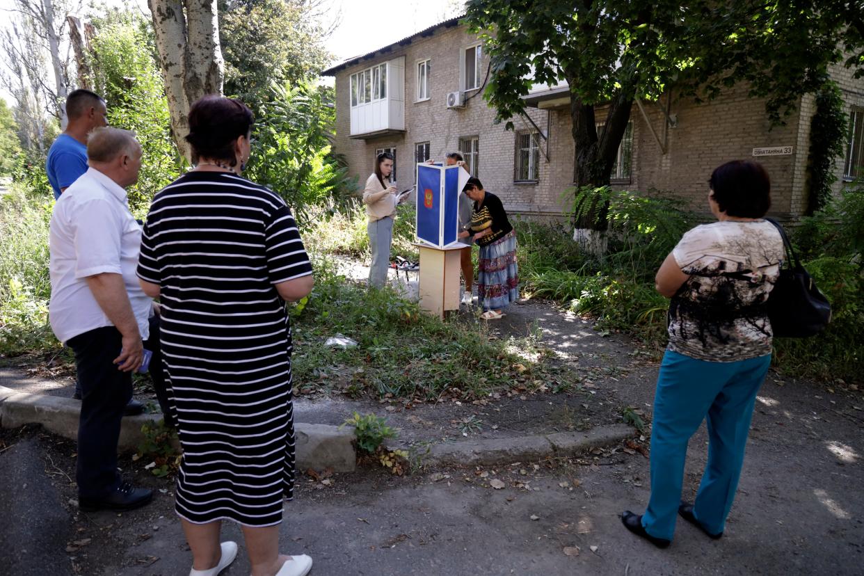 Voters gather to cast their ballots in a street near their apartment building during local elections in Donetsk (Copyright 2023 The Associated Press. All rights reserved)