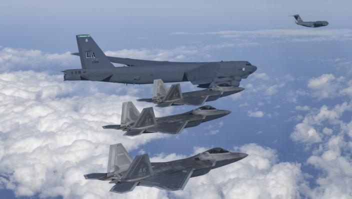 In this photo provided by South Korean Defense Ministry, a U.S. B-52 bomber, C-17, and U.S. Air Force F-22 fighter jets fly over the Korean Peninsula during a joint air drill in South Korea on Dec. 20, 2022.
