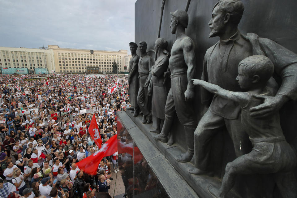 Belarusian opposition supporters gather for a protest rally in front of the government building at Independent Square in Minsk, Belarus, Tuesday, Aug. 18, 2020, with a Soviet era sculptures in the foreground. Workers at more state-controlled companies and factories took part in the strike that began the day before and has encompassed several truck and tractor factories, a huge potash factory that accounts for a fifth of the world's potash fertilizer output and is the nation's top cash earner, state television and the country's most prominent theater. (AP Photo/Dmitri Lovetsky)