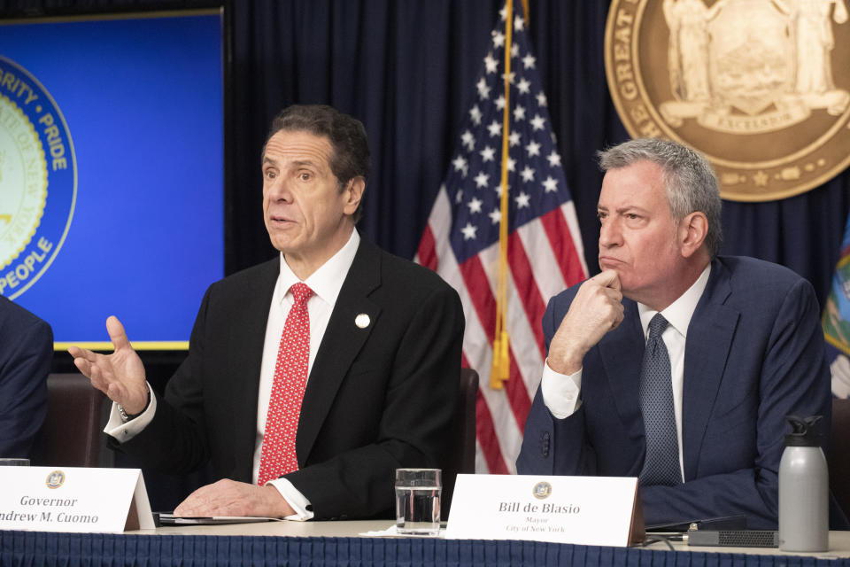 FILE - In this Monday, March 2, 2020, file photo, New York Gov. Andrew Cuomo, left, and Mayor Bill de Blasio discuss the state and city's preparedness for the spread of the coronavirus, in New York. The wife, two children and neighbor of a New York lawyer who is hospitalized in critical condition with COVID-19 have also tested positive for the disease. Gov. Cuomo made the announcement on Wednesday, March 4. (AP Photo/Mark Lennihan, File)