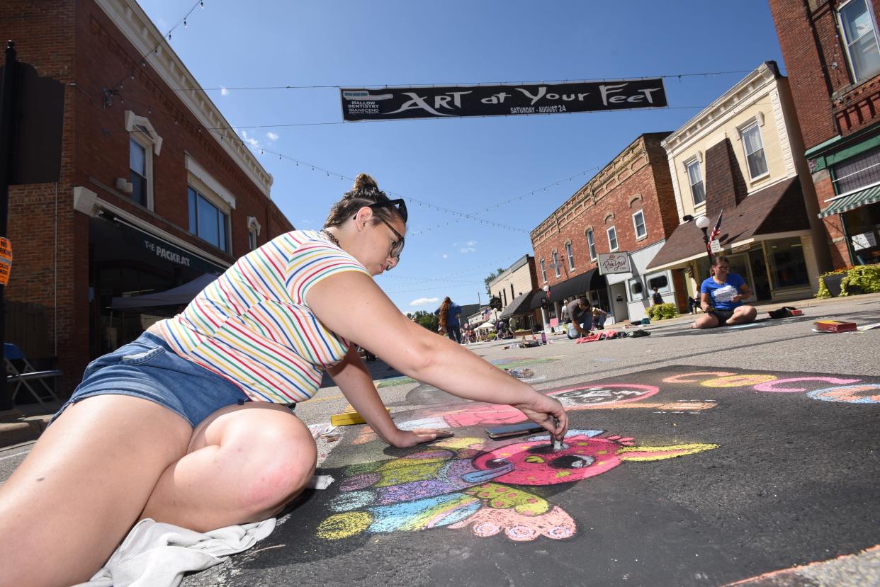 Cassidy Mullins of Blissfield works on a colorful square during the 11th annual Art at Your Feet street art event Aug. 24, 2019, in downtown Blissfield.