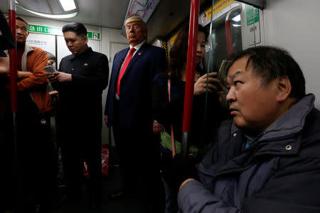 Howard, 37, an Australian-Chinese who is impersonating North Korean leader Kim Jong-un, and Dennis Alan of Chicago, 66, who is impersonating U.S. President Donald Trump, ride a subway train in Hong Kong, China January 25, 2017. REUTERS/Bobby Yip