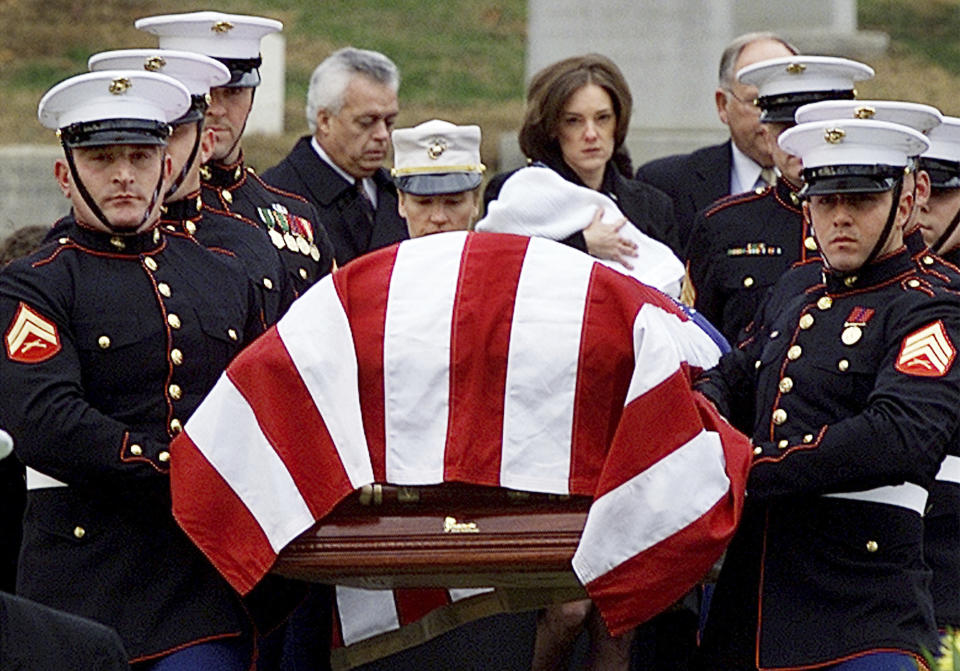 FILE - In this Dec. 10, 2001, file photo Shannon Spann, wife of CIA officer Johnny Michael "Mike" Spann, follows her husband's casket to the grave site, holding her 6-month old son Jake, at Arlington National Cemetery in Arlington, Va. Spann, a Marine turned CIA officer, felt a duty to go to Afghanistan in the wake of the Sept. 11, 2001, attacks. In November of 2001, the 32-year-old CIA paramilitary officer from Winfield, Ala., became the first of 2,448 American service members to be killed in Afghanistan. (AP Photo/Doug Mills, File)