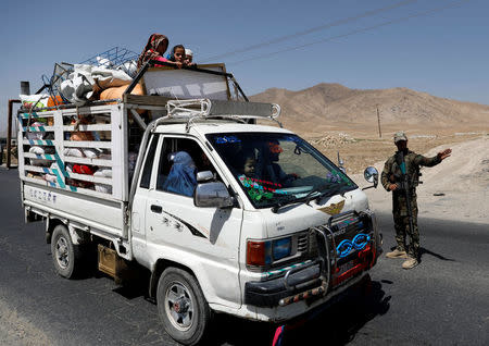 An Afghan National Army (ANA) soldier keeps watch at a checkpoint on the Ghazni highway, while a family is traveling in Maidan Shar, the capital of Wardak province, Afghanistan August 12, 2018. REUTERS/Mohammad Ismail