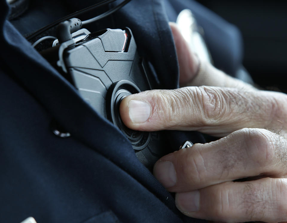 WEST VALLEY CITY, UT - MARCH 2: West Valley City patrol officer Gatrell starts a body camera recording by pressing a button on his chest before he takes a theft report from a construction worker with his newly-issued body camera attached to the side of a pair of glasses on March 2, 2015 in West Valley City, Utah. West Valley City Police Department has issued 190 Taser Axon Flex body cameras for all it's sworn officers to wear starting today.  (Photo by George Frey/Getty Images)
