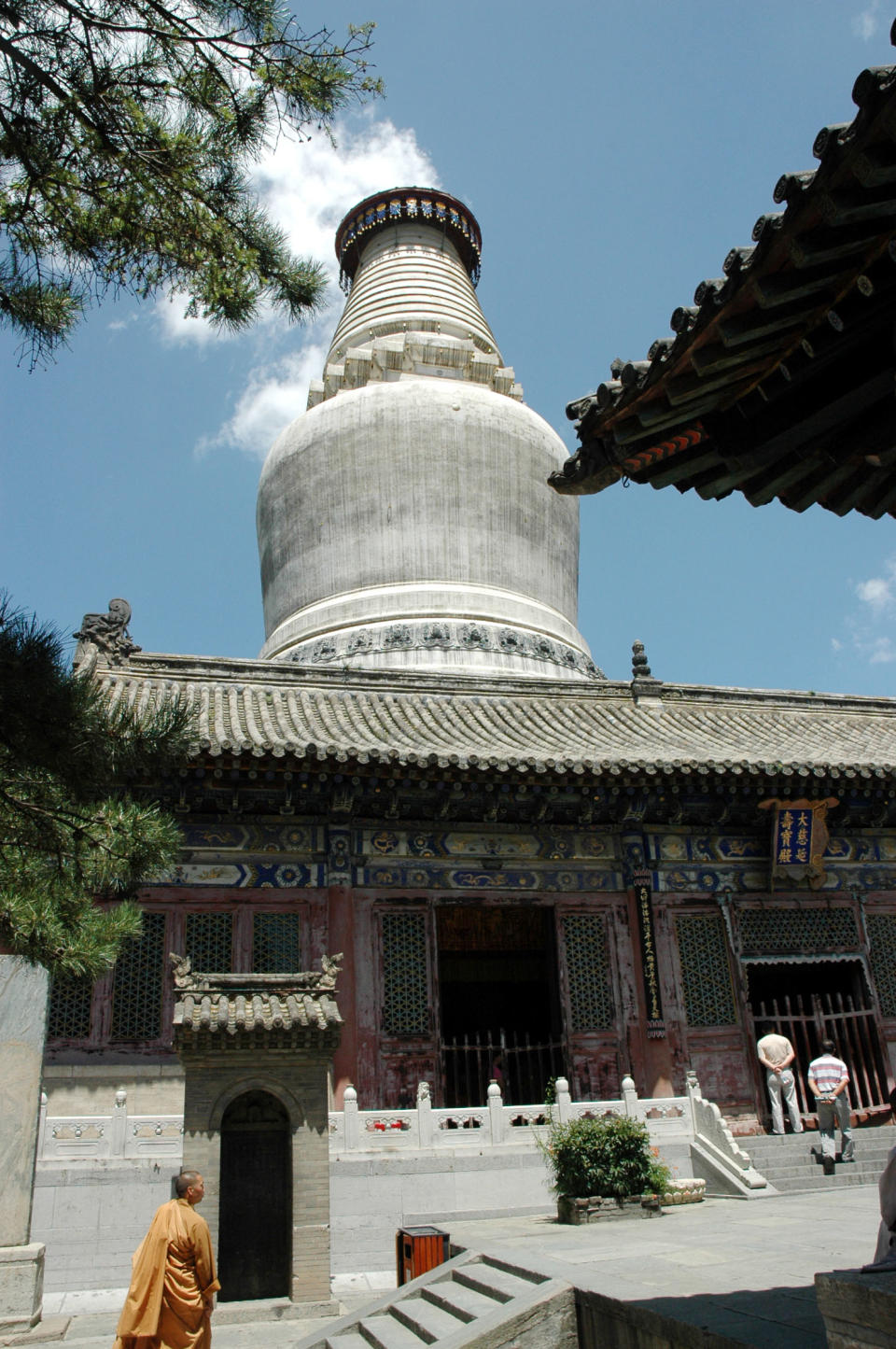 In this photo taken July 18, 2009, a monk walks as tourists visit Tayuan Temple in the scenic Wutai Mountains in Wutai county in north China's Shanxi province. Authorities announced Monday, Oct. 22, 2012, a ban on temples selling shares to investors after leaders of several temples planned to pursue stock market listings for them as commercial entities. (AP Photo) CHINA OUT