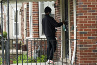 Deares Carey leaves a flyer on a home in Detroit, Tuesday, May 4, 2021. Officials are walking door-to-door to encourage residents of the majority Black city to get vaccinated against COVID-19 as the city's immunization rate lags well behind the rest of Michigan and the United States. (AP Photo/Paul Sancya)