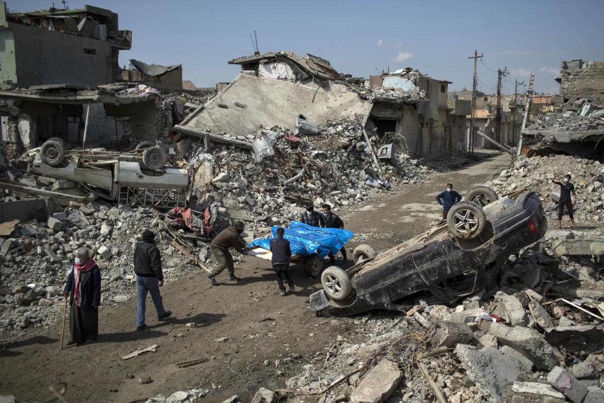 Residents carry the bodies of people killed during fights between Iraq security forces and ISIS in Mosul on March 17. (Photo: Felipe Dana/AP)