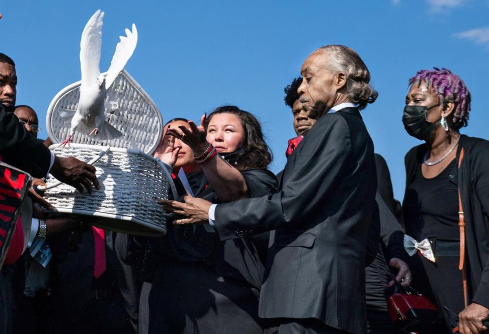 Katie Wright and her husband, Aubrey Wright, along with the Rev. Al Sharpton and family and friends, release doves.