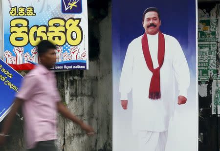 A man walks past a poster of Sri Lanka's former president Mahinda Rajapaksa ahead of a general election, in Galle August 14, 2015. REUTERS/Dinuka Liyanawatte