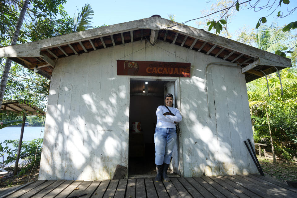 Neilanny Maia stans outside a cocoa processing shed at the Sitio Gimaia Tauare where the fruits are harvested by hand for processing by the De Mendes Chocolates company, on the island of Tauare, in the municipality of Mocajuba, Para state, Brazil, Friday, June 2, 2023. (AP Photo/Eraldo Peres)