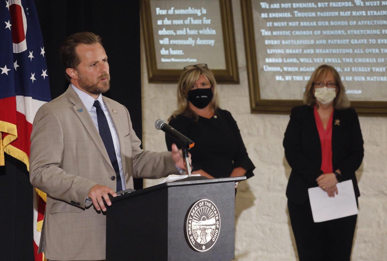 Rep. Rick Carfagna speaks at a press conference to discuss the introduction of legislation that would repeal House Bill 6 ,  Sen. Stephanie Kunze and Rep. Laura Lanese right listen at the Ohio Statehouse July 23, 2020.