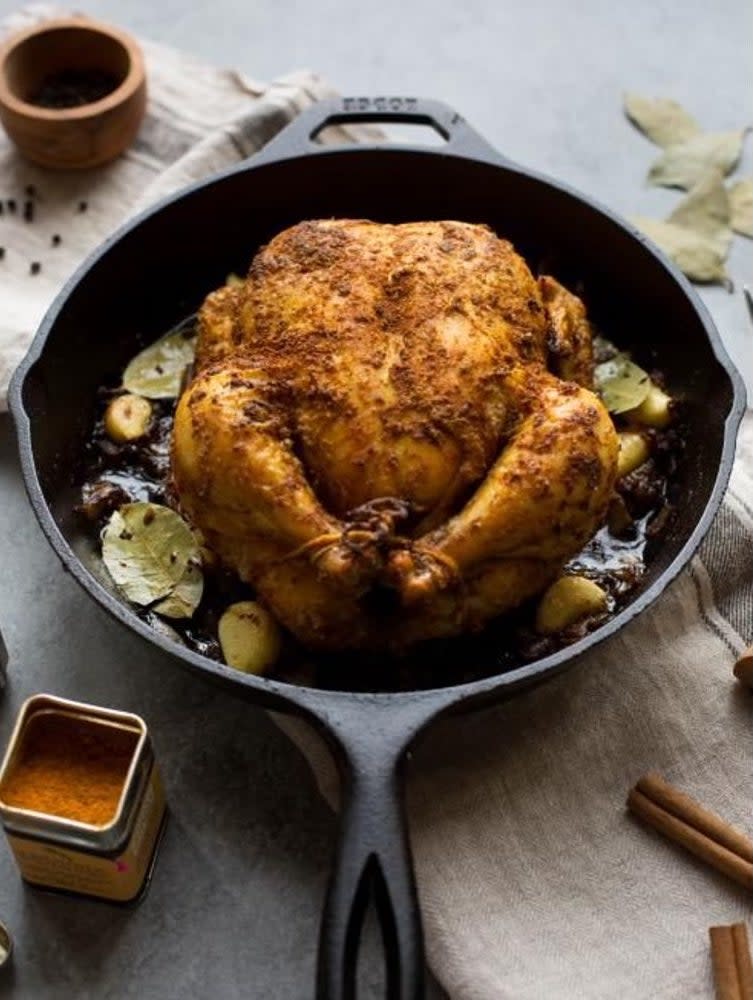 cast iron skillet with a roasted chicken inside