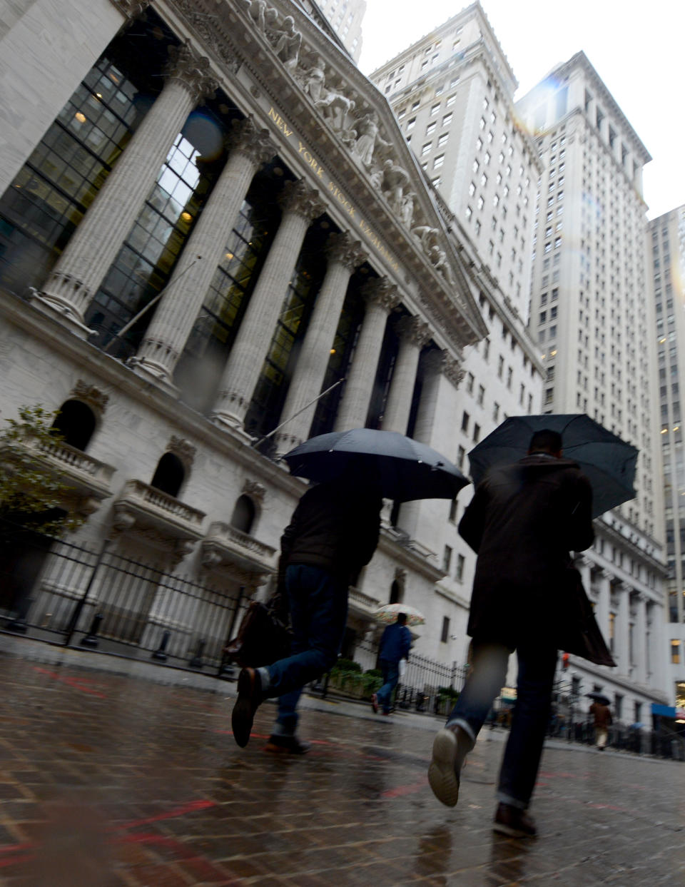 Pedestrians walk in the rain past the New York Stock Exchange the day after Pres. Barack Obama was re-elected, Wednesday, Nov. 7, 2012 in New York. (AP Photo/Henny Ray Abrams)