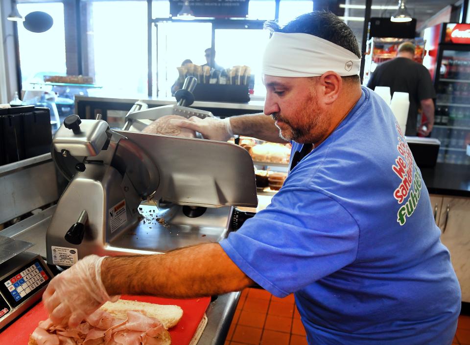 C & C Italian Deli & Sandwich Shop in Greenville. Christopher Kandell, one of the owners of the business, prepares the Italian Combo sandwich: Ham, salami, pepperoni, mortadella, hot capocollo, provolone, roasted peppers, lettuce and tomatoes, with oil and vinegar for a guest.