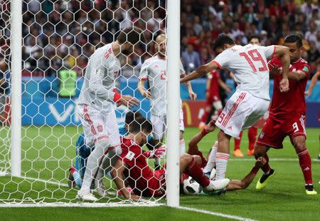 Soccer Football - World Cup - Group B - Iran vs Spain - Kazan Arena, Kazan, Russia - June 20, 2018 Spain's Diego Costa and Gerard Pique in action with Iran's Saeid Ezatolahi on the goal line REUTERS/Sergio Perez