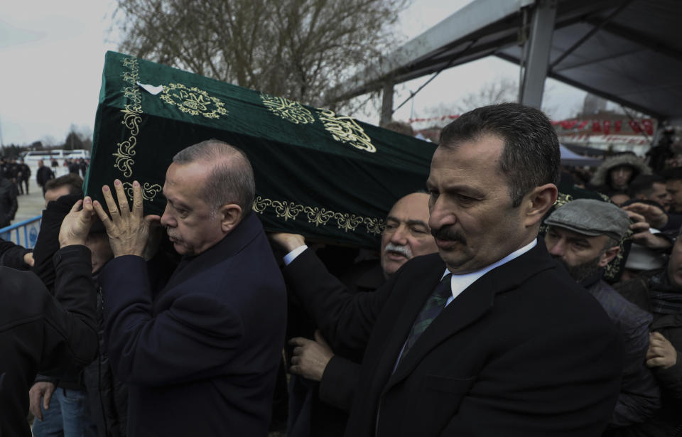 Turkey's President Recep Tayyip Erdogan, left, carries a coffin as he joins hundreds of mourners who attend the funeral prayers for nine members of Alemdar family killed in a collapsed apartment building, in Istanbul, Saturday, Feb. 9, 2019. Erdogan says there are "many lessons to learn" from the collapse of a residential building in Istanbul where at least 17 people have died.(AP Photo/Emrah Gurel)