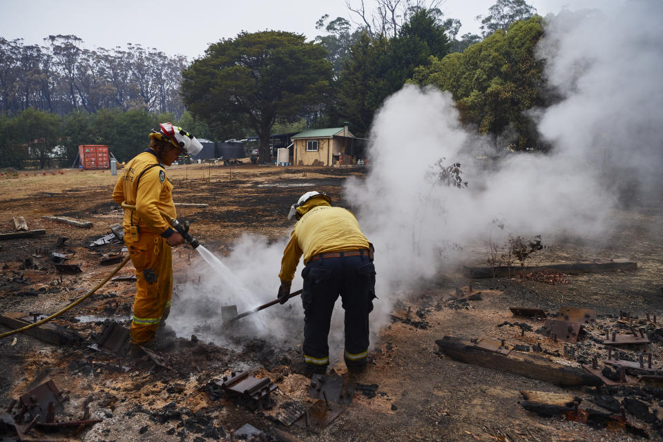 An RFS Crew attempts to put out a smouldering pile of railway sleepers in Wingello, Australia. 