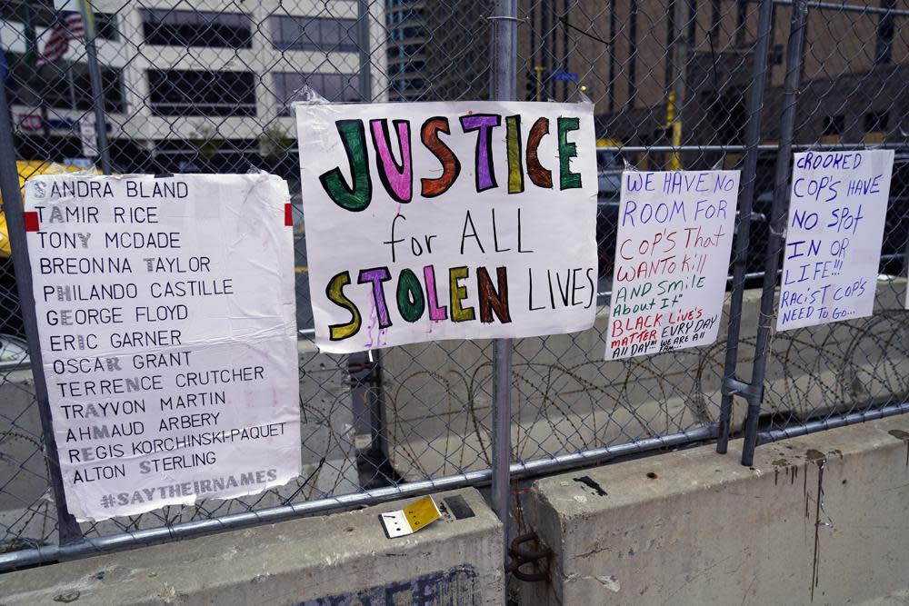 New signs are on a fence at the Hennepin County Government Center, Monday, April 19, 2021, in Minneapolis during closing arguments being heard in the trial of former Minneapolis police officer Derek Chauvin continues. (AP Photo/Jim Mone)