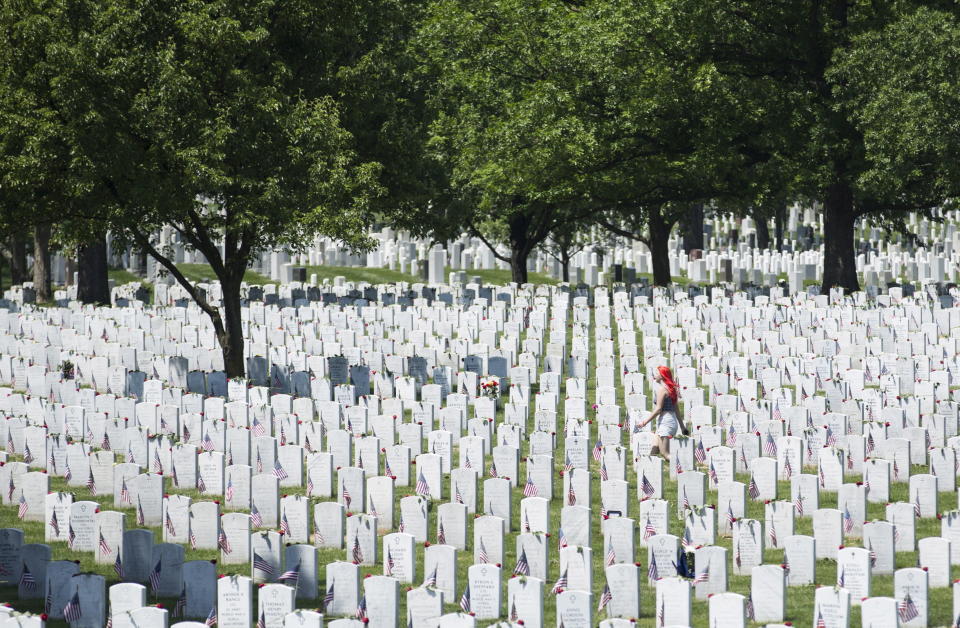 A woman walks past graves on Memorial Day at Arlington National Cemetery in Arlington, Virginia, on May 25, 2015.