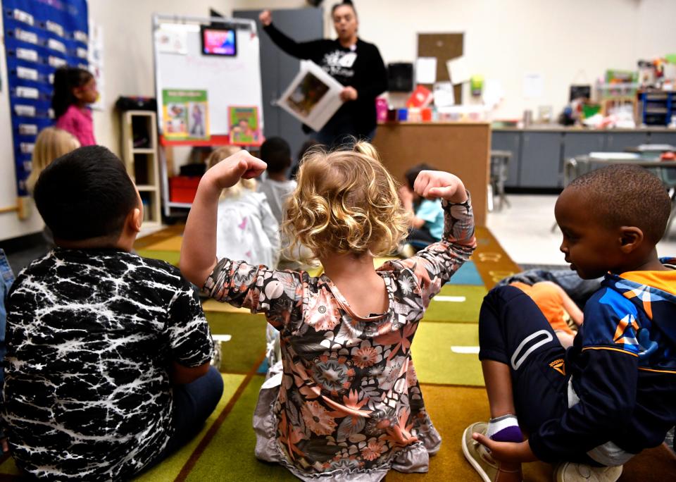 A student demonstrates her muscles as Araceli Urvina leads a class on the human body and health for 4- and 5-year-olds at the Orange Street Day Nursery on March 10.