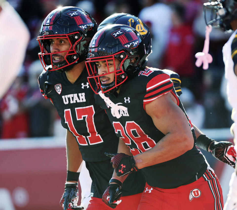 Utah safety Sione Vaki (28) celebrates his touchdown with Utah wide receiver Devaughn Vele (17) during an NCAA college football game against California in Salt Lake City, Saturday, Oct. 14, 2023. (Jeffrey D. Allred/The Deseret News via AP)