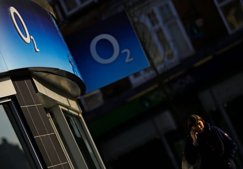 FILE PHOTO: A woman speaks on her mobile telephone outside an O2 shop in Loughborough