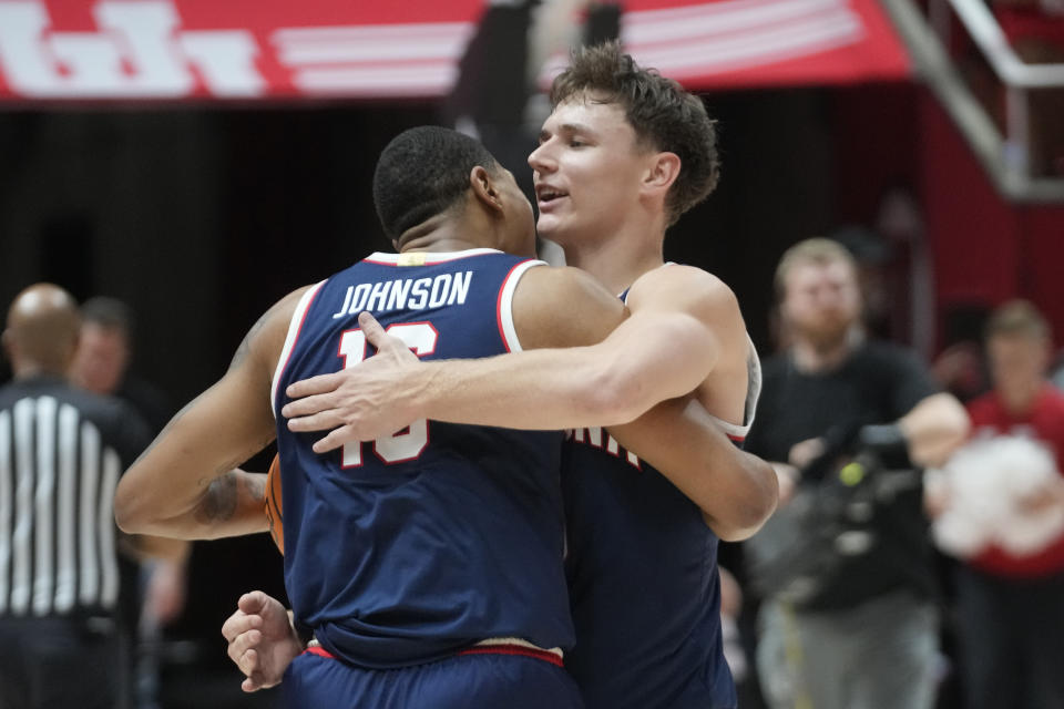 Arizona's Pelle Larsson, right, hugs Keshad Johnson (16) after the team's win over Utah in three overtimes in an NCAA college basketball game Thursday, Feb. 8, 2024, in Salt Lake City. (AP Photo/Rick Bowmer)