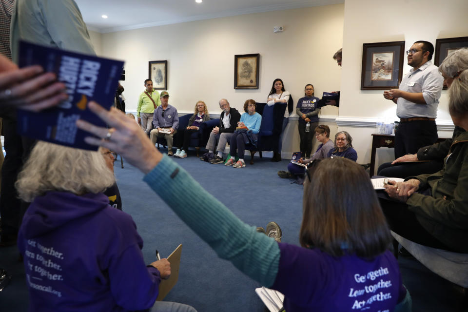 Ricky Hurtado, candidato demócrata a la Cámara de Representantes estatal de Carolina del Norte, a la derecha, habla con voluntarios antes de salir a contactar con votantes en Mebane, Carolina del Norte, el domingo 8 de marzo de 2020. (AP Foto/Jacquelyn Martin)