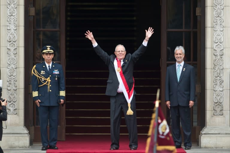 Peru's President Pedro Pablo Kuczynski waves to supporters as he arrives at the Government Palace after his swearing-in ceremony in Lima on July 28, 2016