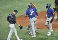 Tampa Bay Rays' Ryan Yarbrough (48) walks past Texas Rangers' Jose Trevino, left, Nate Lowe (30) and Adolis Garcia after they scored on Nick Solak's bases-loaded double during the fourth inning of a baseball game Tuesday, April 13, 2021, in St. Petersburg, Fla. (AP Photo/Steve Nesius)