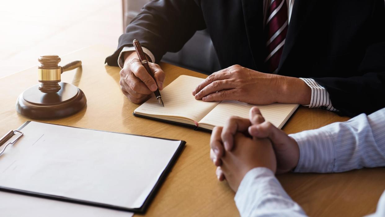 Close up of gavel, Male lawyer or judge Consult with client and working with Law books, report the case on table in modern office, Law and justice concept.