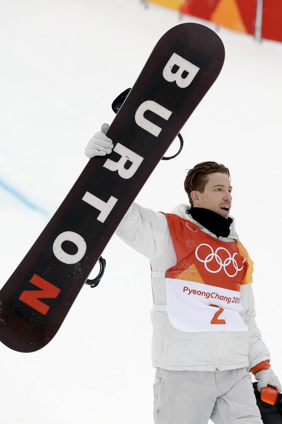 FILE - In this Feb. 14, 2018, file photo, Shaun White, of the United States, holds up his Burton snowboard as he celebrates his run during the men's halfpipe finals at the 2018 Winter Olympics in Pyeongchang, South Korea. Jake Burton Carpenter, the man who changed the game on the mountain by fulfilling a grand vision of what a snowboard could be, died Wednesday night, Nov. 20, 2019, of complications stemming from a relapse of testicular cancer. He was 65. (AP Photo/Gregory Bull, File)