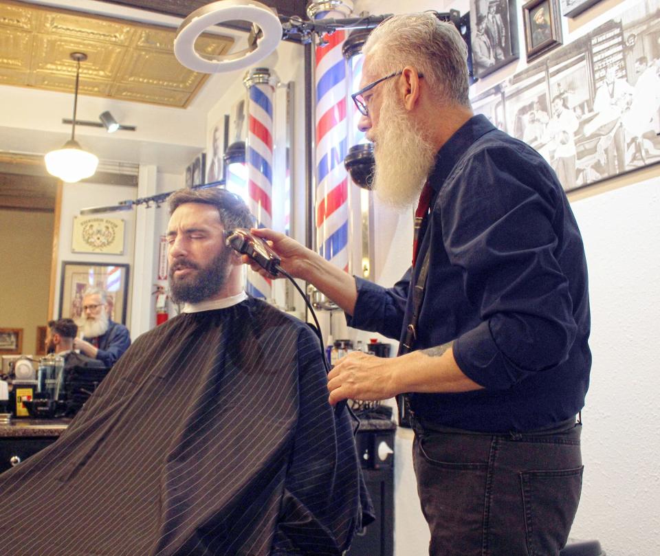 Gentlemen's Barbershop Owner Nick Mischel (right) cuts customer Tony Harper's hair at Pueblo's only Prohibition-era barbershop, in the Union Depot.