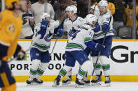 Vancouver Canucks center Pius Suter (24) is congratulated after his goal by teammates during the third period in Game 6 of an NHL hockey Stanley Cup first-round playoff series Friday, May 3, 2024, in Nashville, Tenn. The Canucks won 1-0. (AP Photo/George Walker IV)