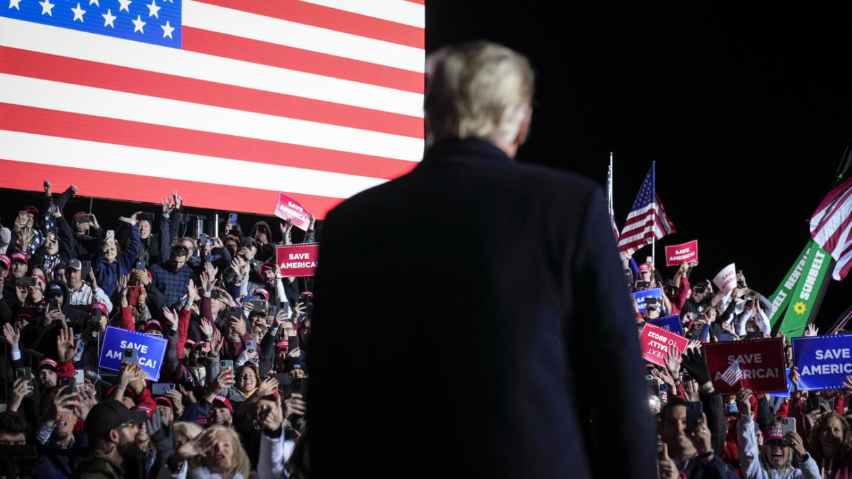 Former President Donald Trump walks across a stage at a rally.